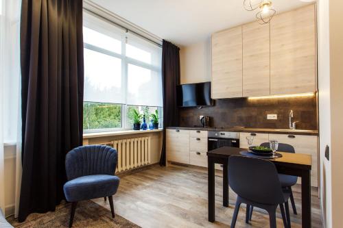 a kitchen with a table and chairs and a dining room at Old Town Trio Apartments in Vilnius
