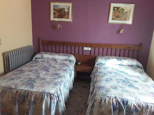 2 camas en una habitación con paredes moradas en Casa Rural Martina, en Guadalaviar