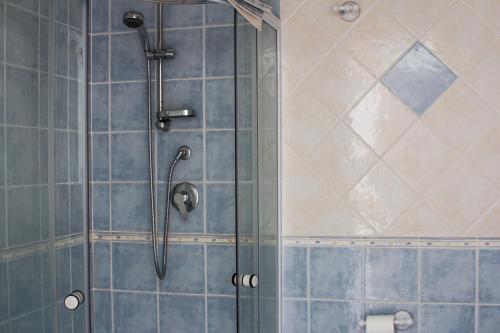 y baño con ducha y azulejos azules. en B&B CasettAzzurri, en Reggio Calabria