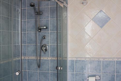 レッジョ・ディ・カラブリアにあるB&B CasettAzzurriの青いタイルのバスルーム(シャワー付)