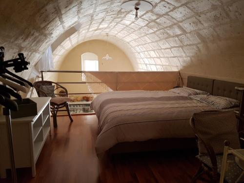 a bedroom with a large bed in a brick wall at Casa Elena in Matera