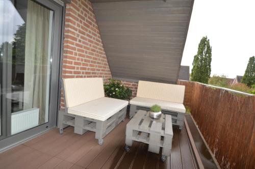 two chairs and a coffee table on a balcony at Appartement Sendenhorst in Sendenhorst