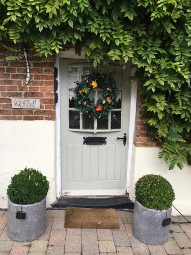 Una porta bianca con una corona di fiori di Tudor Farm B&B a Elston