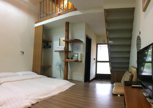a bedroom with a bed and a spiral staircase at Oliver Tree B&B in Fenglin