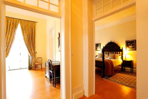 a bedroom with a bed and a desk and a window at Parador Casa Da Insua in Penalva do Castelo