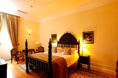 a bedroom with a large bed with yellow walls at Parador Casa Da Insua in Penalva do Castelo