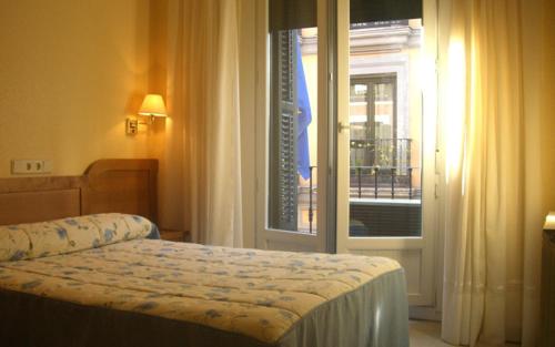 a hotel room with a bed and a window at Hostal Benamar in Madrid