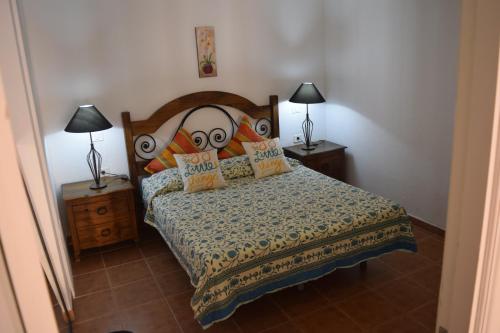 a bedroom with a bed and two lamps on tables at Sol y Luna en Caleta de Fuste in Caleta De Fuste