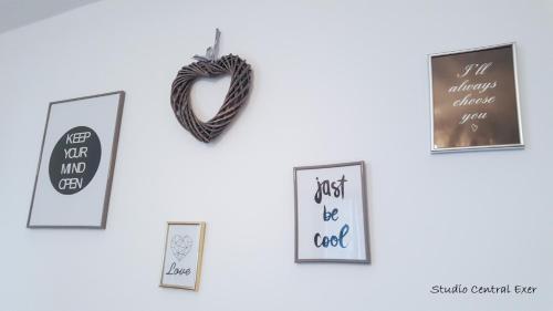 een muur met ingelijste foto's en een hartornament bij Studio Central Exer II in Boekarest