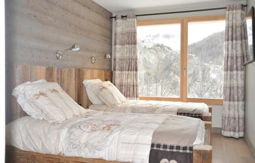 - 2 lits dans une chambre avec une grande fenêtre dans l'établissement Odalys Chalet Le Mas des Neiges, à Valloire