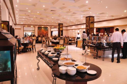 a restaurant with several tables with food on them at Pearl Continental Hotel, Karachi in Karachi