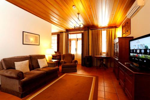 a living room with a couch and a flat screen tv at Parador Casa Da Insua in Penalva do Castelo
