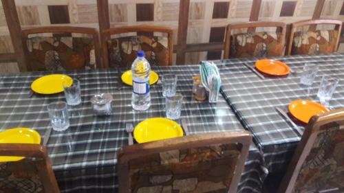 a table with yellow plates and a bottle of water on it at Blooming Dale Hotel in Srinagar