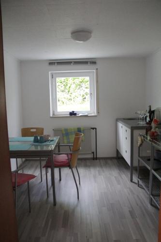 jadalnia ze stołem i krzesłami oraz oknem w obiekcie Nürnberg Business Apartment w mieście Heroldsberg