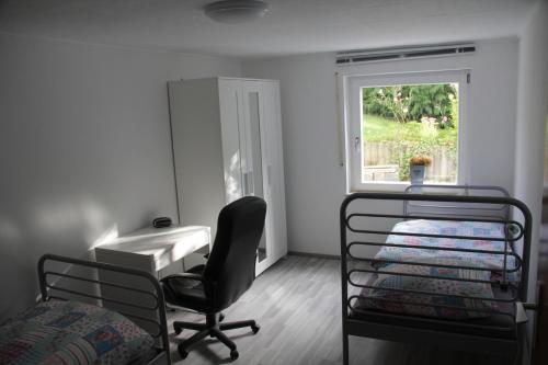 sypialnia z biurkiem, krzesłem i oknem w obiekcie Nürnberg Business Apartment w mieście Heroldsberg