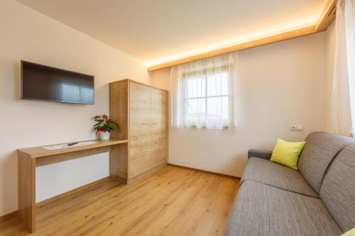 a living room with a couch and a television at Krebslechnerhof in Brunico