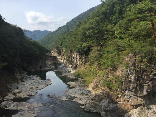 a river in a canyon with a mountain at kinugawaonsen Fukumatsu in Nikko