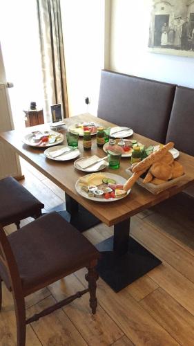 a wooden table with plates of food on it at Pension Sunnseitn - Gasthof - Café - Weinkeller in Haslach an der Mühl
