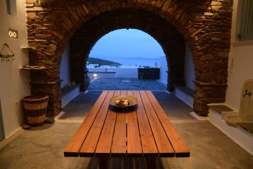 アギオス・イオアニスにあるTinos Porto Villasの窓付きの部屋の中央に木製テーブル