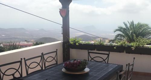 a table with a bowl of flowers on a balcony at Varanski Vista in San Miguel de Abona