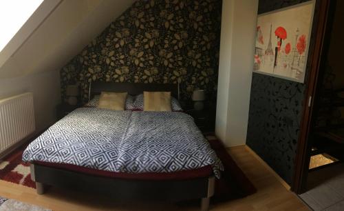 a bedroom with a bed with a black and white comforter at Korona Apartman in Kaposvár