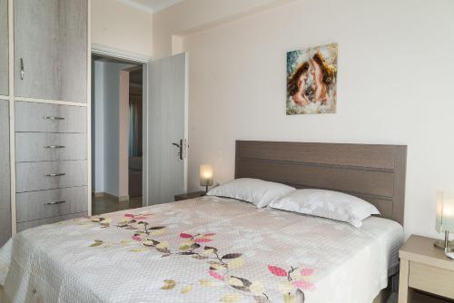 1 dormitorio con 1 cama grande con colcha de flores en Villa Kampos en Vanáton