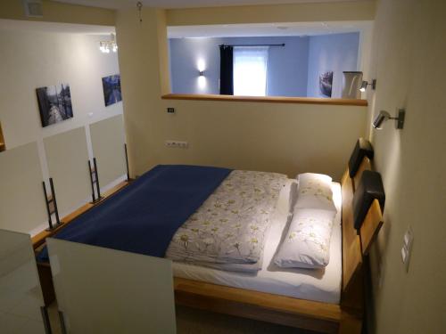 a bedroom with a large bed with a blue blanket at Tauberterrasse in Wertheim