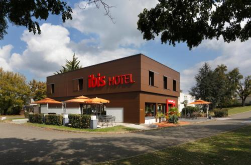 a building with a bus hotel with umbrellas at ibis Le Mans Est Pontlieue in Le Mans