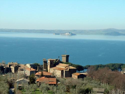 un groupe de maisons devant une grande masse d'eau dans l'établissement La Riserva Montebello, à Bolsena