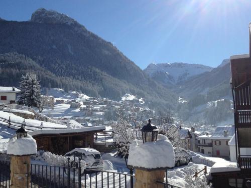 a view of a town with snow covered mountains at Hotel Patrizia Dolomites Glamour in Moena