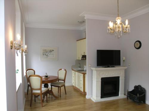 - un salon avec une table à manger et une cheminée dans l'établissement Apartmán LUX Škroupova, à Karlovy Vary