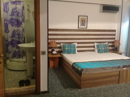 فندق غاليري باكو في باكو: غرفة نوم بسرير وحمام مع حوض