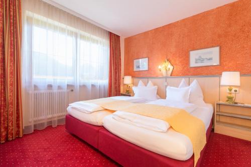 a hotel room with two beds and a window at Hotel-Pension Das Platzl in Schladming