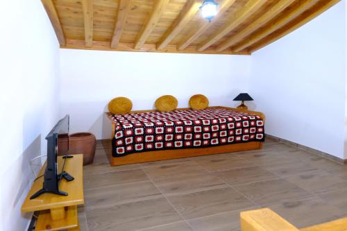 a bedroom with a bed and a tv and a table at Quinta do Fragoso in Alto do Sul