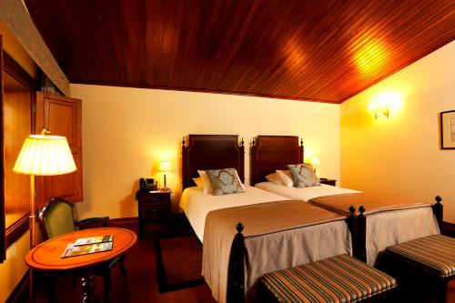 a hotel room with two beds and a table at Parador Casa Da Insua in Penalva do Castelo