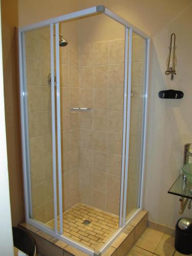 a shower with a glass enclosure in a bathroom at Top House Bed and Breakfast in Ladybrand