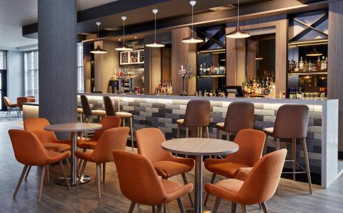 a restaurant with tables and chairs and a bar at Leonardo Hotel Nottingham - formerly Jurys Inn in Nottingham