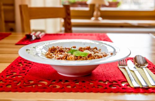 a plate of food on a table with a red napkin at Kurpiowska Kraina in Wydmusy