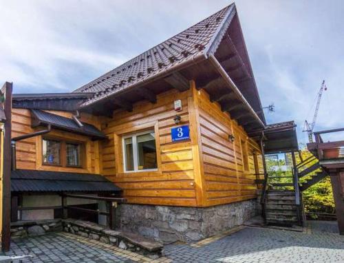 a wooden house with a sign on it at Apartamenty ForRest Nowotarska in Zakopane