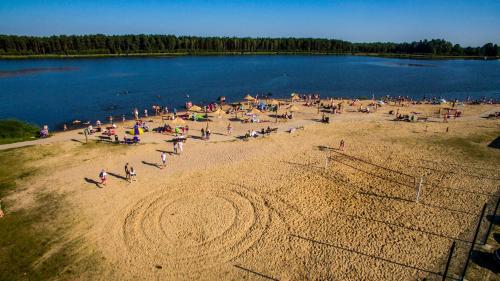 a group of people on a beach near a lake at Kurpiowska Kraina in Wydmusy