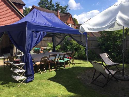 a blue tent with chairs and a table in a yard at Hurstbourne in Camberley