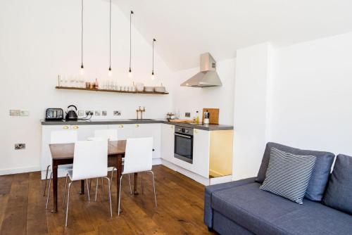 uma cozinha e sala de estar com uma mesa e um sofá em The Workshop @ The Grange em Lydd