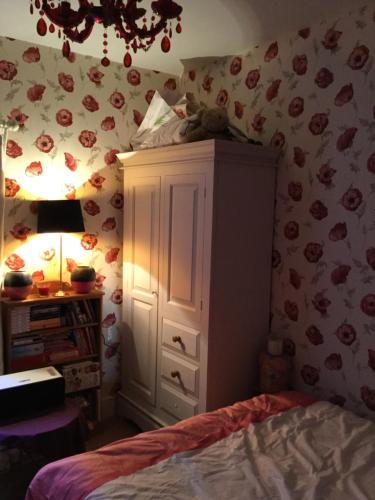 a bedroom with a bed and a cabinet and a lamp at Hurstbourne in Camberley