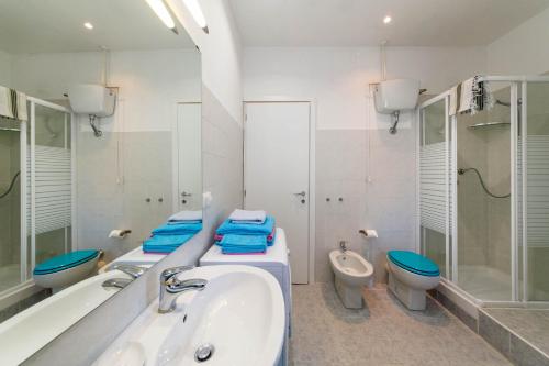 a bathroom with two toilets and a tub and a sink at house LeoMar di Maria in Genova