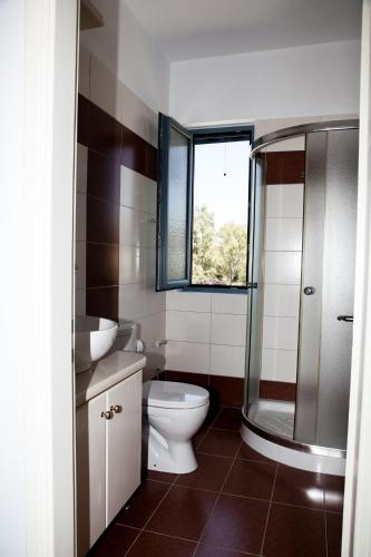 a bathroom with a toilet and a sink and a shower at Romanos Xi in Xi