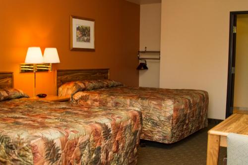 A bed or beds in a room at Cottonwood Inn & Suites