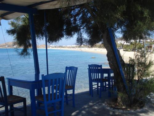 a group of blue tables and chairs on the beach at Agios Prokopios Hotel in Agios Prokopios