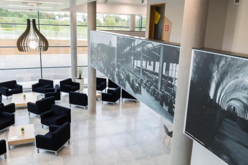 a lobby with black chairs and a large screen at B&B HOTEL Longwy Porte du Luxembourg in Longwy