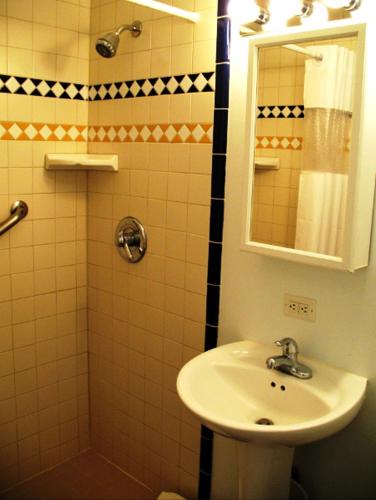 a bathroom with a sink and a shower with a mirror at Golden West Motel in Klamath Falls