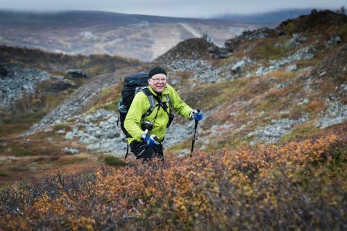 a man with a backpack hiking on a mountain at Hotell Bruksvallsliden in Bruksvallarna